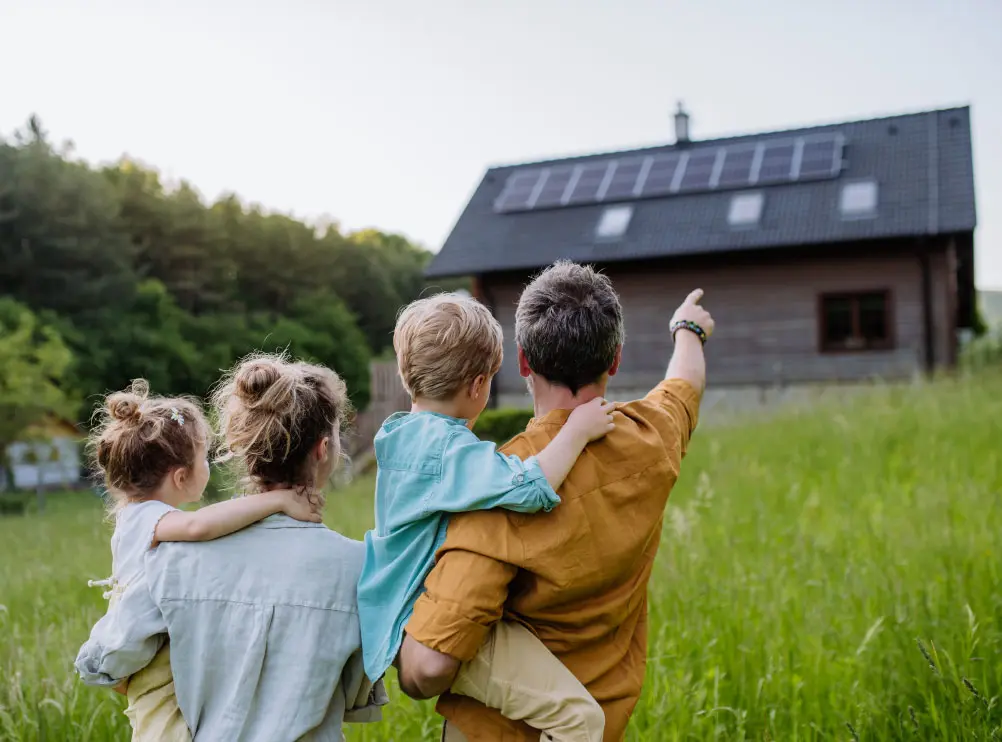 Famille admirant l'installation solaire sur la toiture de leur maison