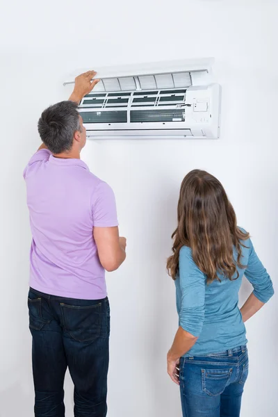 Photo d'un couple regardant le fonctionnement d'une climatisation